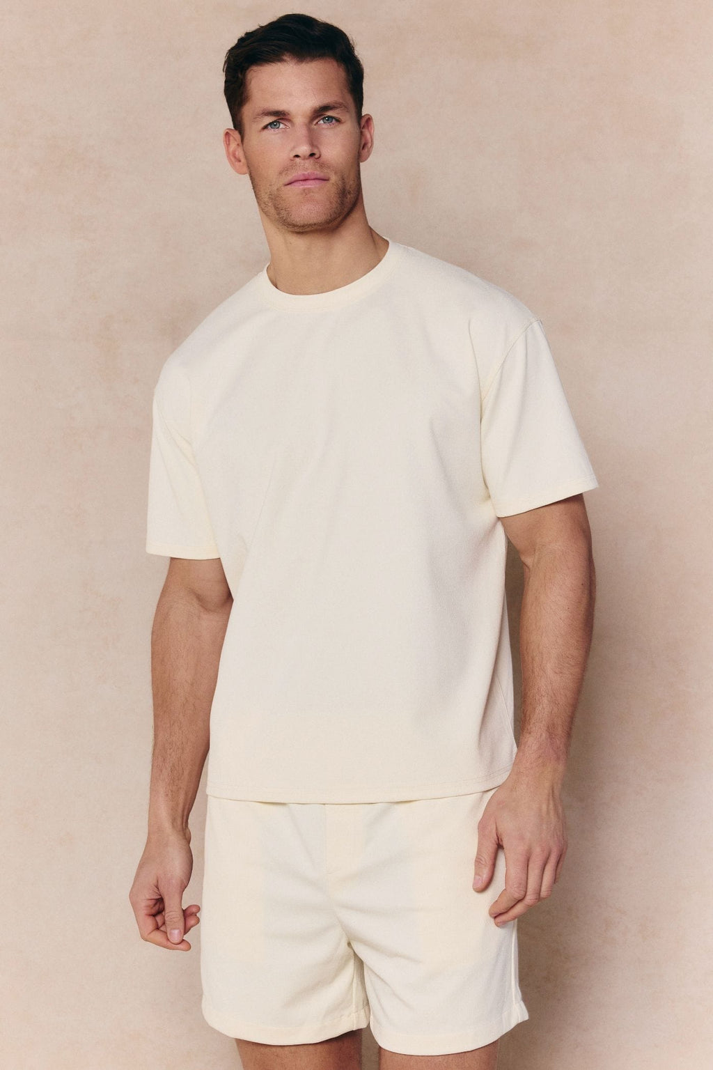 Man wearing an ecru Tomas Crew Neck Crinkled T-shirt with matching shorts.