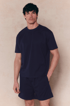 Man in a navy Tomas Crew Neck Crinkled T-shirt and matching shorts, relaxed fit.