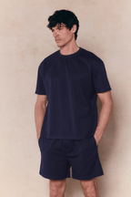 Man in a navy Tomas Crew Neck Crinkled T-Shirt and matching shorts, relaxed fit.