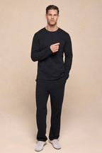 Man wearing a black Tyler long sleeve crew neck t-shirt with a chest pocket and matching black pants.