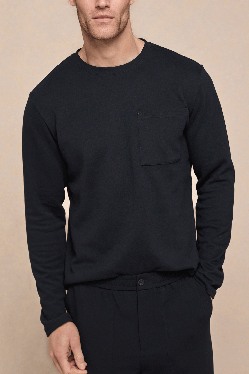 Men's black long sleeve crew neck t-shirt with a chest pocket, made from heavyweight cotton-rich fabric.