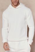 Man wearing an ivory Zarco crinkled jersey hoodie and matching sweatpants.