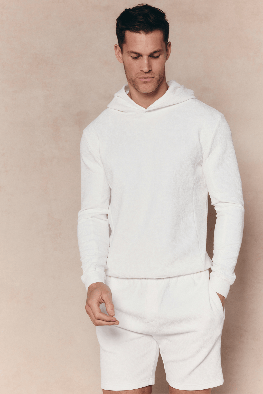 Man wearing an ivory Zarco crinkled jersey short and matching hoodie, relaxed fit.