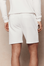 Rear view of a person wearing ivory Zarco crinkled jersey shorts with a matching long-sleeve top.